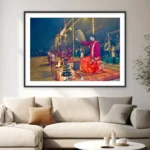 Photograph of a kneeling priest raising a chamar at the Ganga Aarti in Varanasi with lamps and crowd behind
