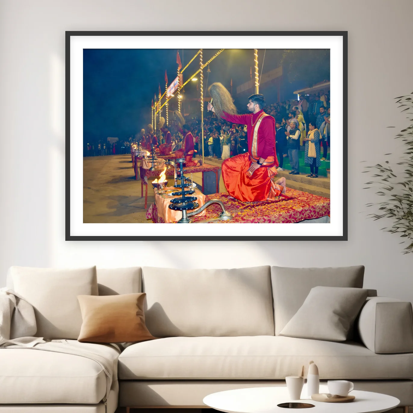 Photograph of a kneeling priest raising a chamar at the Ganga Aarti in Varanasi with lamps and crowd behind