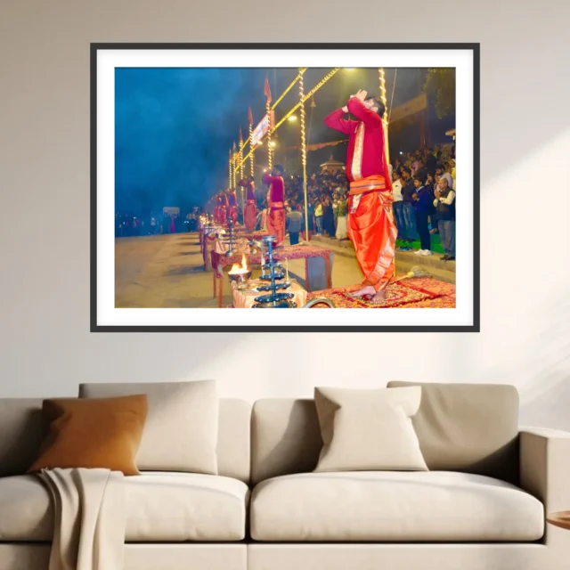 Photograph of a priest blowing a conch at the Ganga Aarti in Varanasi with lamps, smoke and crowd behind