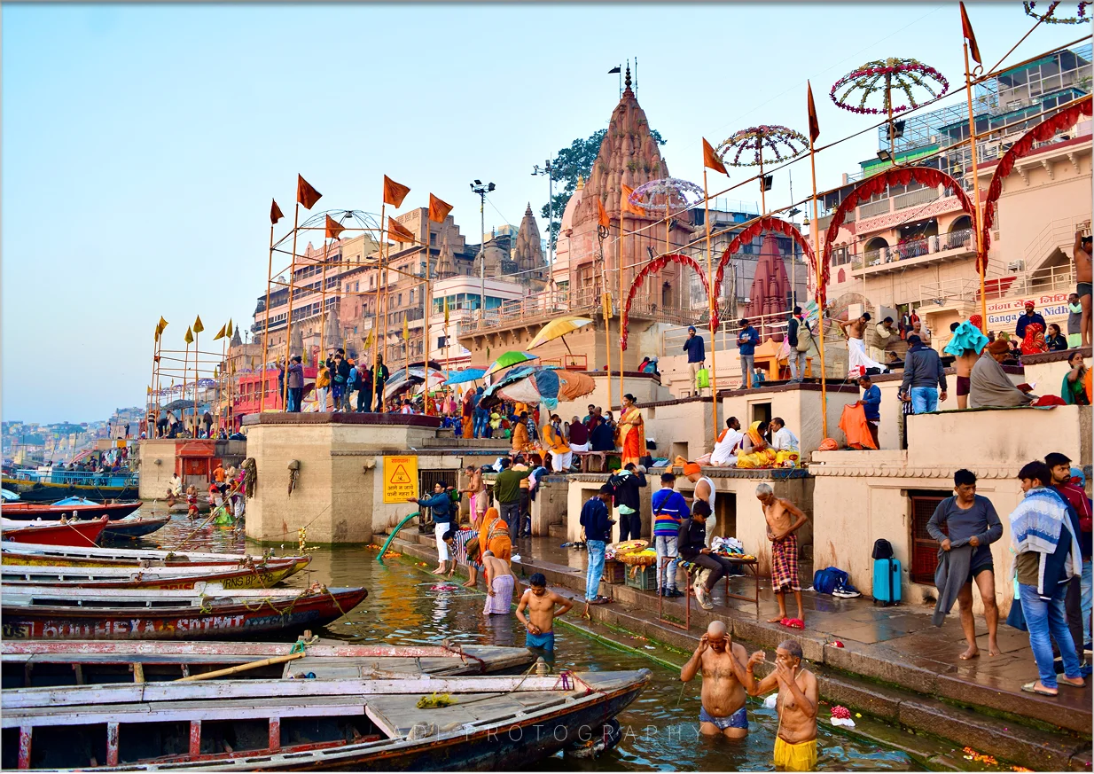 Varanasi ghats with colorful boats and historic riverside buildings along the Ganges